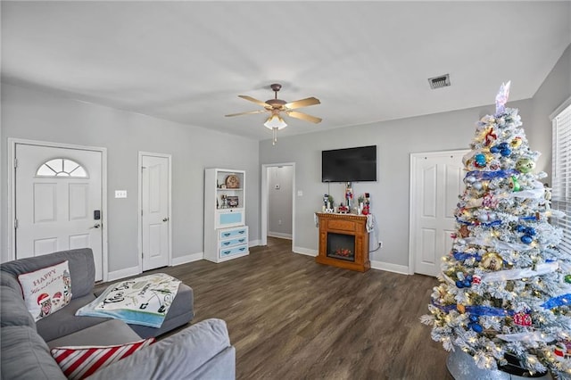 living room with ceiling fan and dark wood-type flooring