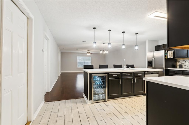 kitchen featuring ceiling fan, sink, light hardwood / wood-style flooring, decorative light fixtures, and decorative backsplash