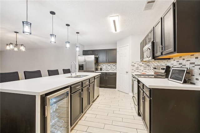 kitchen with a breakfast bar area, wine cooler, stainless steel appliances, and decorative light fixtures