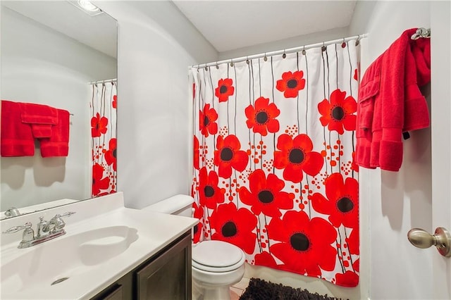 bathroom featuring tile patterned floors, vanity, toilet, and walk in shower