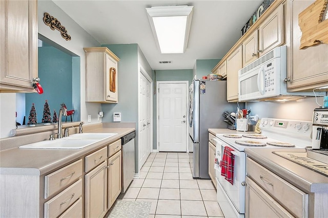 kitchen with light brown cabinets, white appliances, sink, and light tile patterned floors