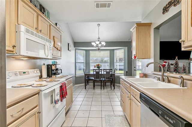 kitchen with white appliances, lofted ceiling, an inviting chandelier, sink, and decorative light fixtures