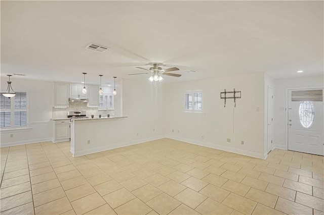 unfurnished living room with ceiling fan and light tile patterned floors