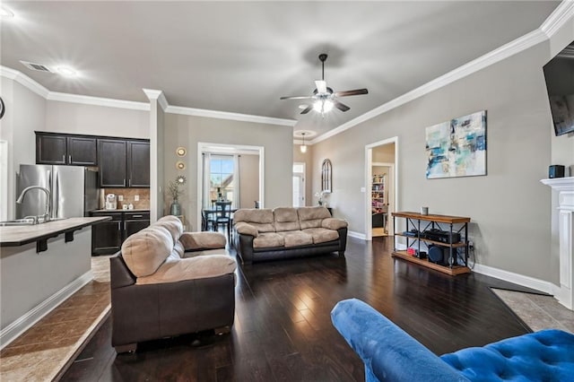 living room featuring sink, crown molding, dark hardwood / wood-style floors, and ceiling fan