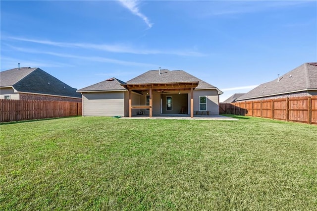 rear view of property with a yard and a patio area