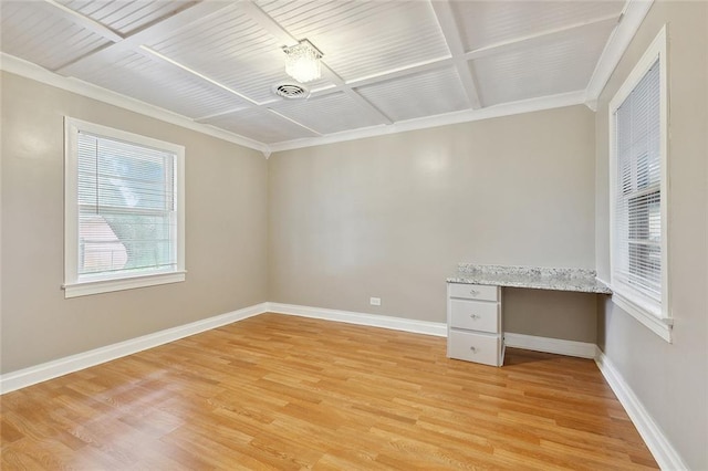 unfurnished office with crown molding, built in desk, and light wood-type flooring