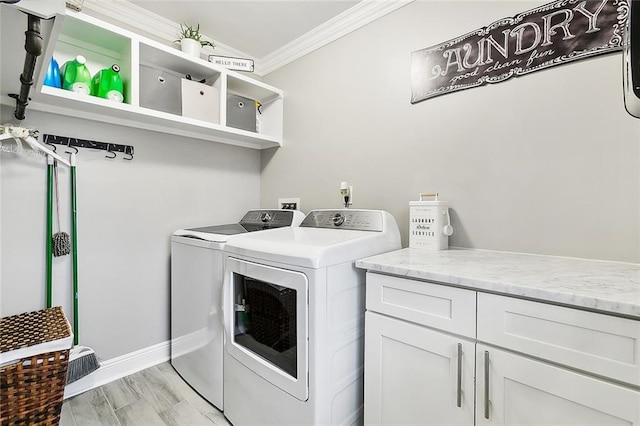 clothes washing area featuring crown molding, washer and dryer, and light hardwood / wood-style floors