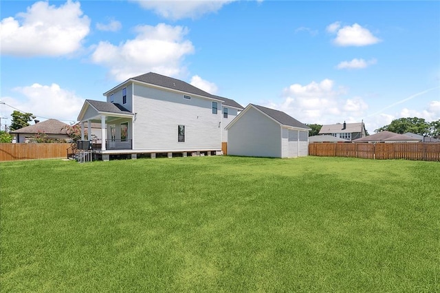 back of property featuring a lawn and an outbuilding