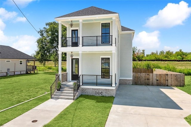 view of front of house featuring a porch, a balcony, and a front lawn