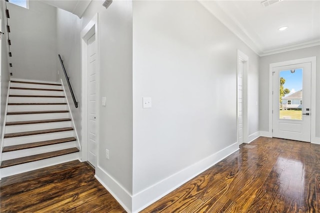 foyer with crown molding and dark wood-type flooring