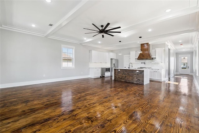 unfurnished living room with beam ceiling, ceiling fan, sink, dark hardwood / wood-style flooring, and crown molding