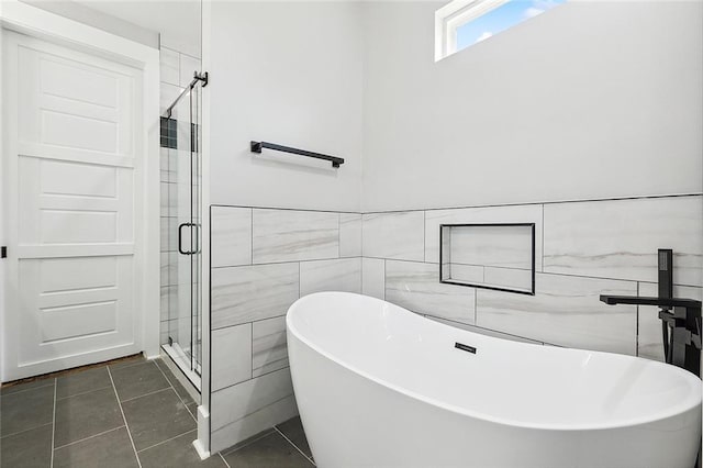 bathroom with tile patterned flooring, separate shower and tub, and tile walls