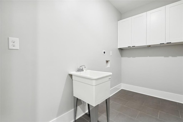 washroom featuring dark tile patterned flooring, electric dryer hookup, and cabinets