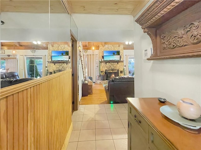 kitchen featuring a healthy amount of sunlight, a stone fireplace, and light tile patterned floors