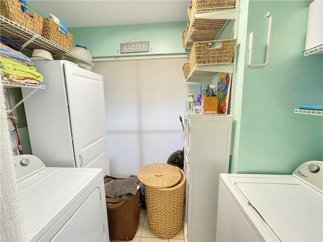 clothes washing area with light tile patterned floors and washer and clothes dryer