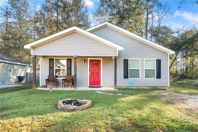 bungalow-style home featuring central AC, a front yard, a porch, and an outdoor fire pit