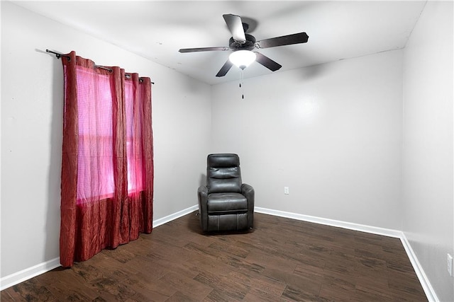 living area featuring ceiling fan and dark wood-type flooring