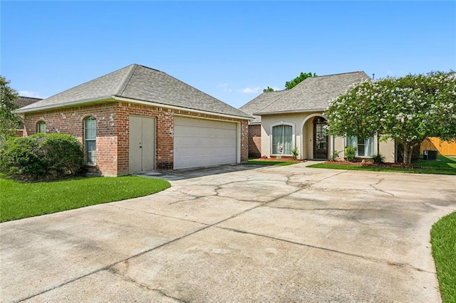 single story home with a garage and a front lawn