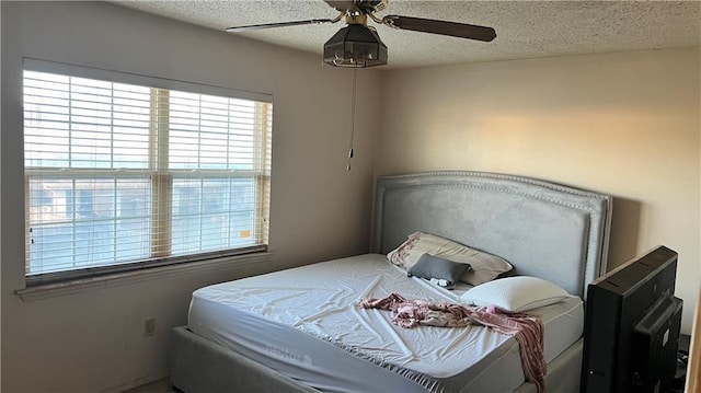 bedroom featuring ceiling fan and a textured ceiling