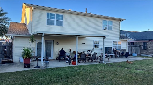 rear view of property featuring a lawn and a patio