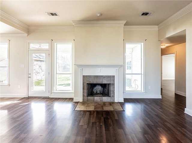 unfurnished living room with a tile fireplace, dark hardwood / wood-style flooring, and crown molding