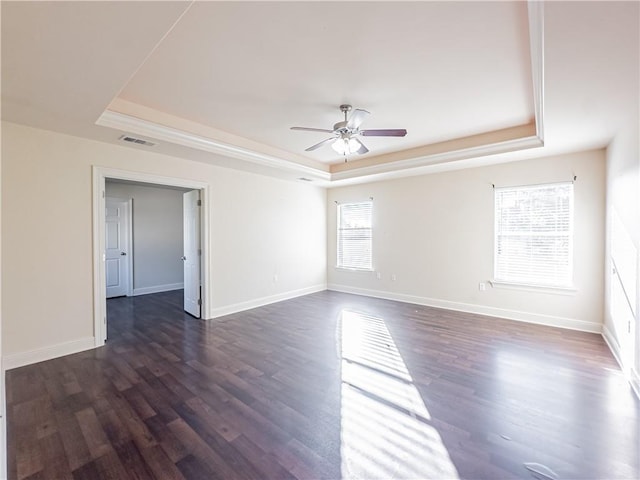 spare room with dark hardwood / wood-style floors, ceiling fan, and a tray ceiling