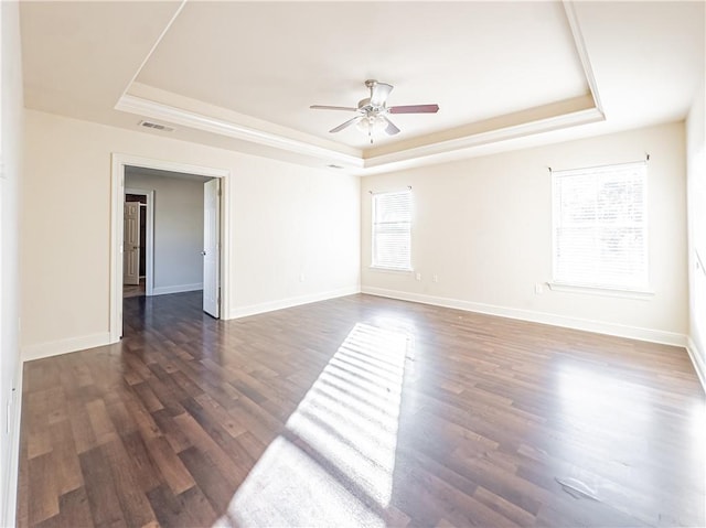 spare room featuring a raised ceiling, ceiling fan, and dark hardwood / wood-style flooring