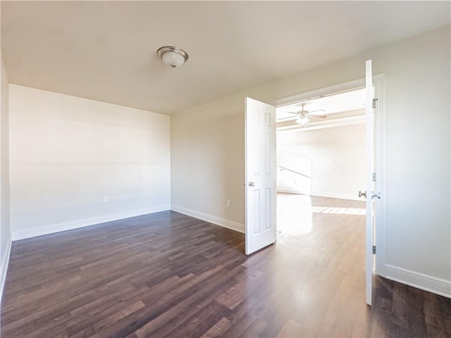 spare room with dark hardwood / wood-style flooring and ceiling fan