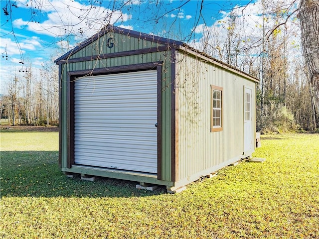 view of outbuilding featuring a garage and a lawn