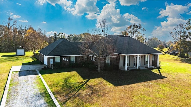 view of front of property featuring an outbuilding, a front lawn, a porch, and a garage