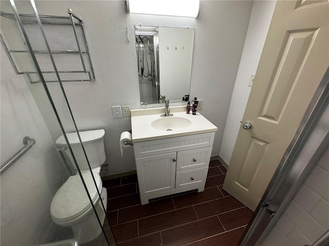 bathroom with vanity, toilet, and an enclosed shower