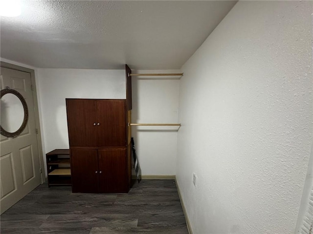 interior space featuring a textured ceiling and dark hardwood / wood-style floors