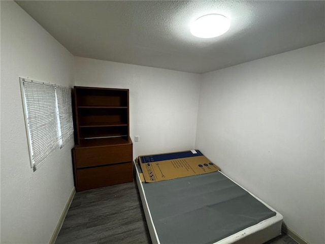 bedroom with a textured ceiling and dark wood-type flooring