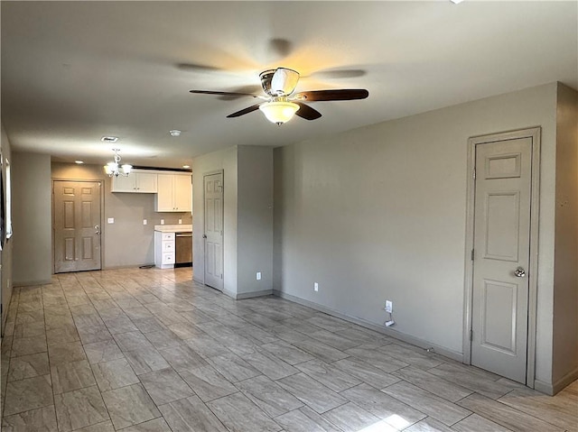 unfurnished living room featuring ceiling fan with notable chandelier