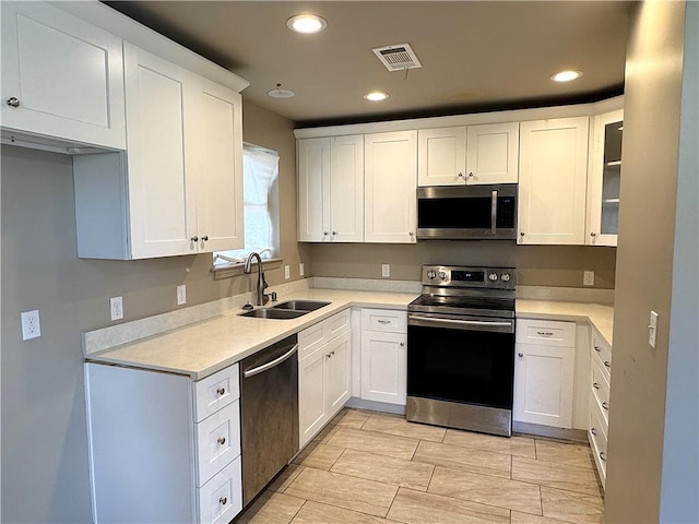 kitchen with white cabinetry, sink, and stainless steel appliances