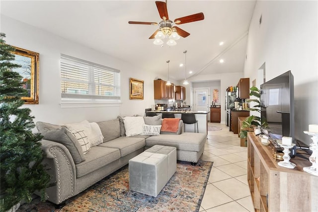 living room featuring ceiling fan, light tile patterned floors, and vaulted ceiling