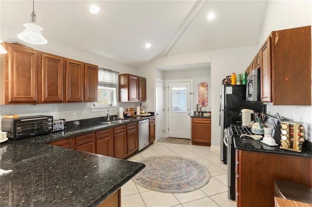 kitchen with sink, lofted ceiling, decorative light fixtures, light tile patterned floors, and appliances with stainless steel finishes