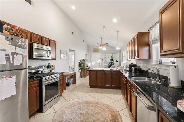 kitchen featuring ceiling fan, sink, kitchen peninsula, decorative light fixtures, and appliances with stainless steel finishes