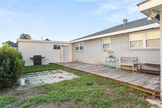 rear view of property with a wooden deck and a yard