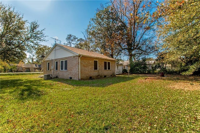 view of side of property with crawl space, a yard, brick siding, and central AC