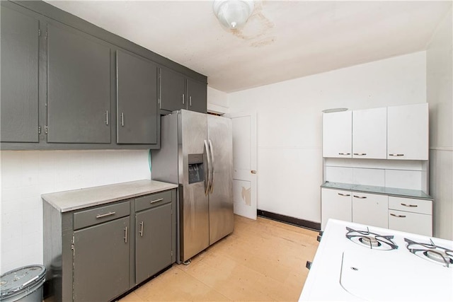 kitchen with light floors, white cabinetry, light countertops, and stainless steel fridge with ice dispenser