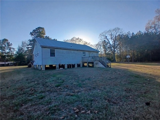 view of side of home featuring a lawn and a deck