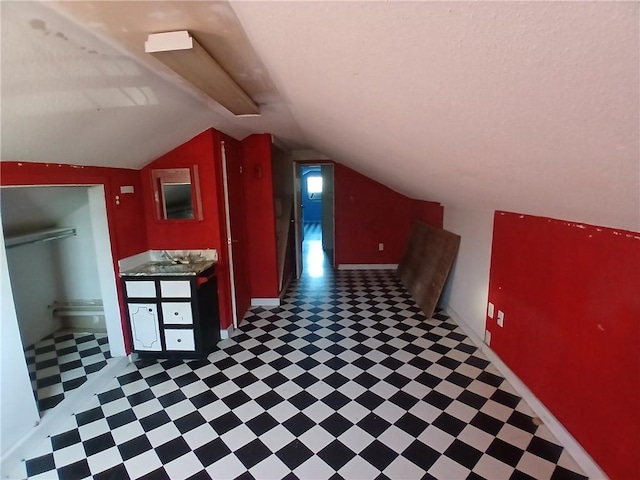 additional living space featuring vaulted ceiling and sink