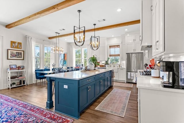 kitchen with blue cabinetry, pendant lighting, white cabinets, and stainless steel appliances