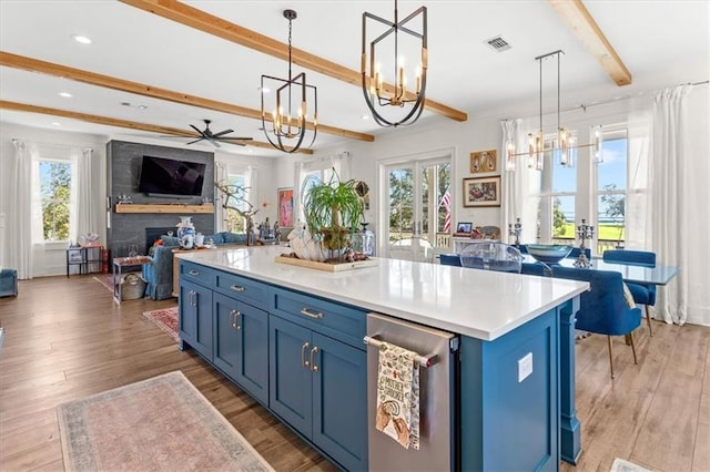 kitchen with a kitchen island, hanging light fixtures, ceiling fan with notable chandelier, and blue cabinets