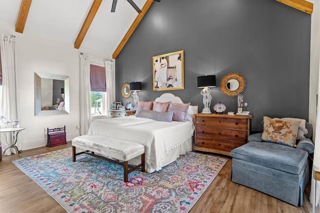 bedroom with beam ceiling, wood-type flooring, and high vaulted ceiling