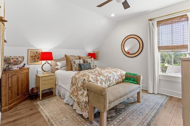 bedroom with ceiling fan, light wood-type flooring, and vaulted ceiling