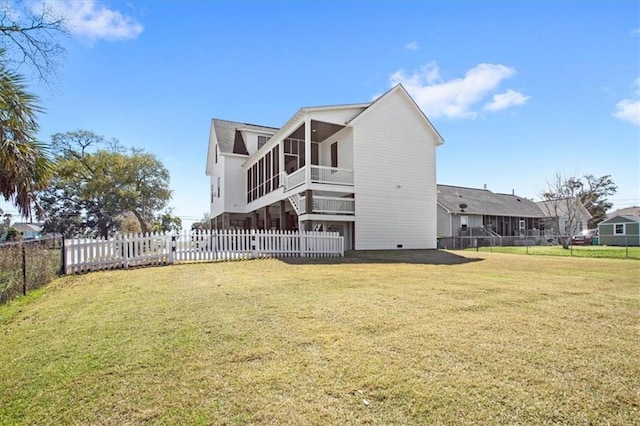 back of property featuring a sunroom and a lawn