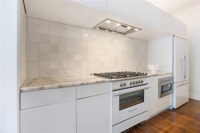 301 S Toulme St Unit 108, Bay Saint Louis, MS 39520 - kitchen featuring dark wood-type flooring, stainless steel stove, light stone countertops, tasteful backsplash, and white cabinetry