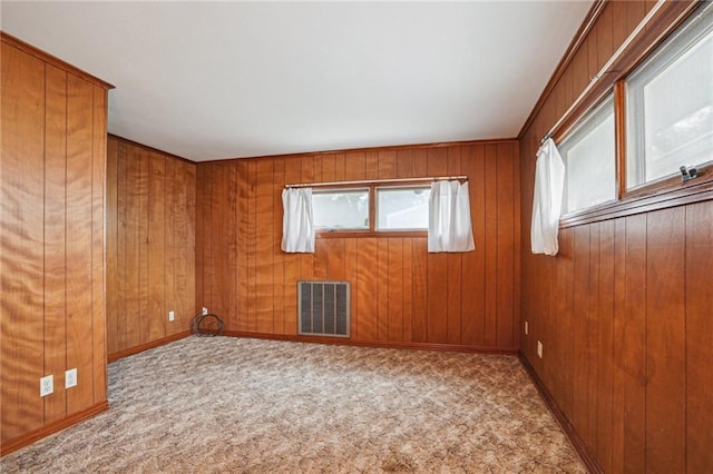 carpeted empty room with wood walls